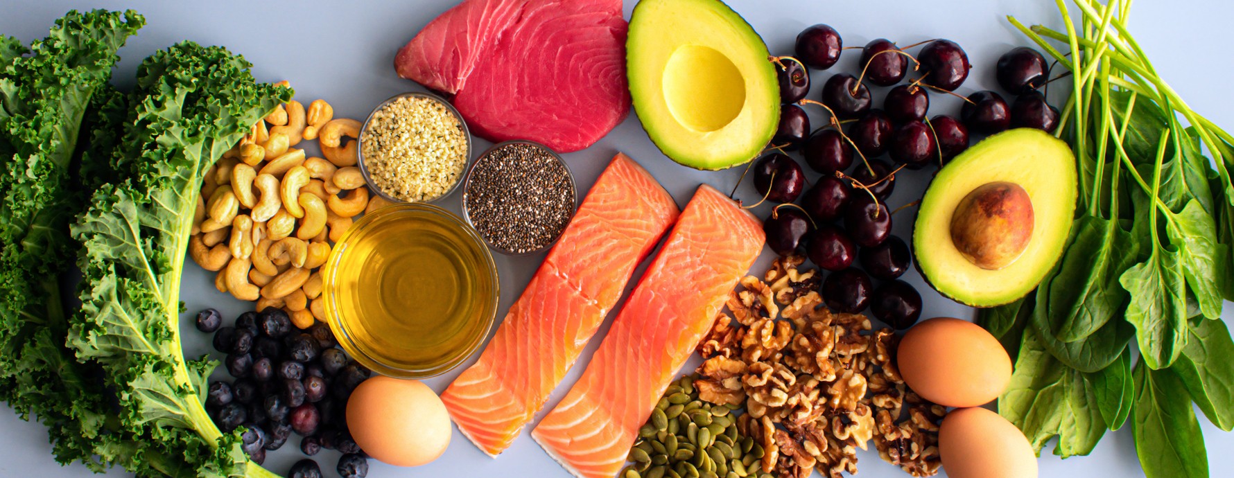 Variety of healthy foods like fish, nuts, seeds, fruit, and vegetables.